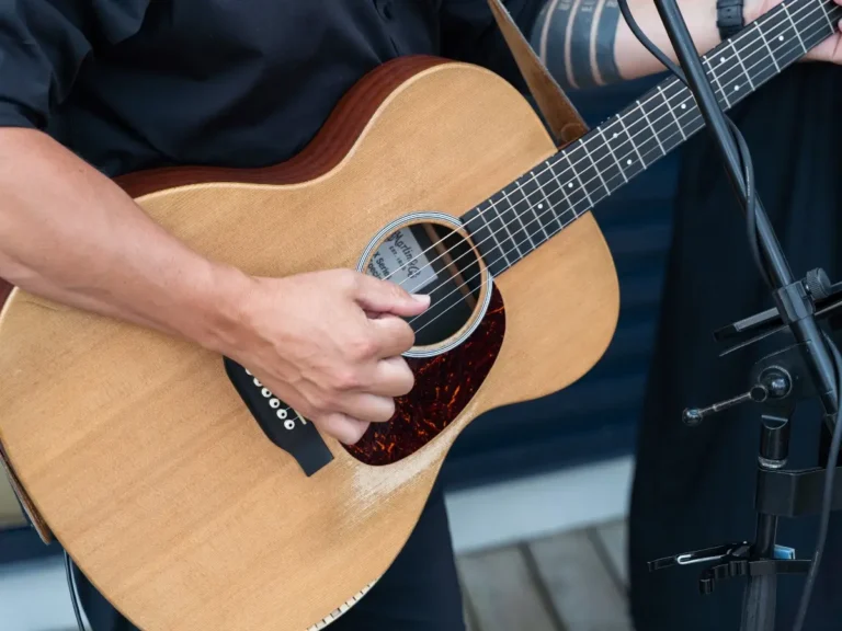 Close‑up of a guitar being played during a live band performance at a Minneapolis commercial real‑estate event by UAV Vision Media — capturing the energy of the moment